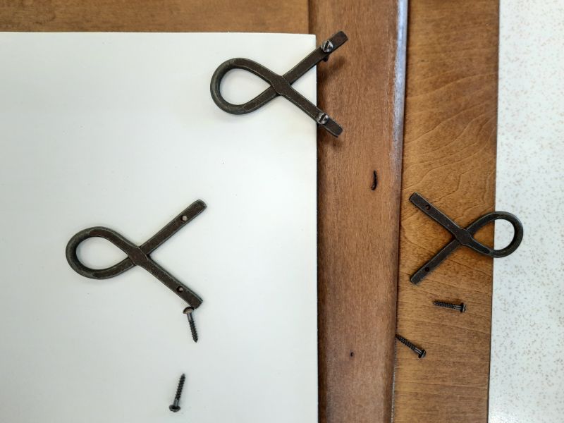 Cross hook with fixing screws, in iron with rustic treatment